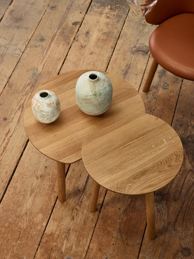 Wooden coffee table with 2 vases on top of it.