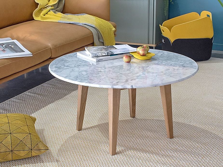 Round coffee table with a white marble surface and wooden legs.