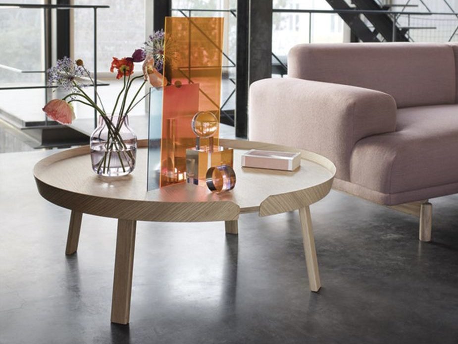 A modern living space with a round wooden coffee table.