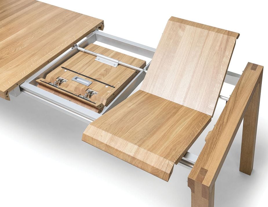 Close-up of a wooden extendable table mechanism showcasing its metal sliders and wooden sections.
