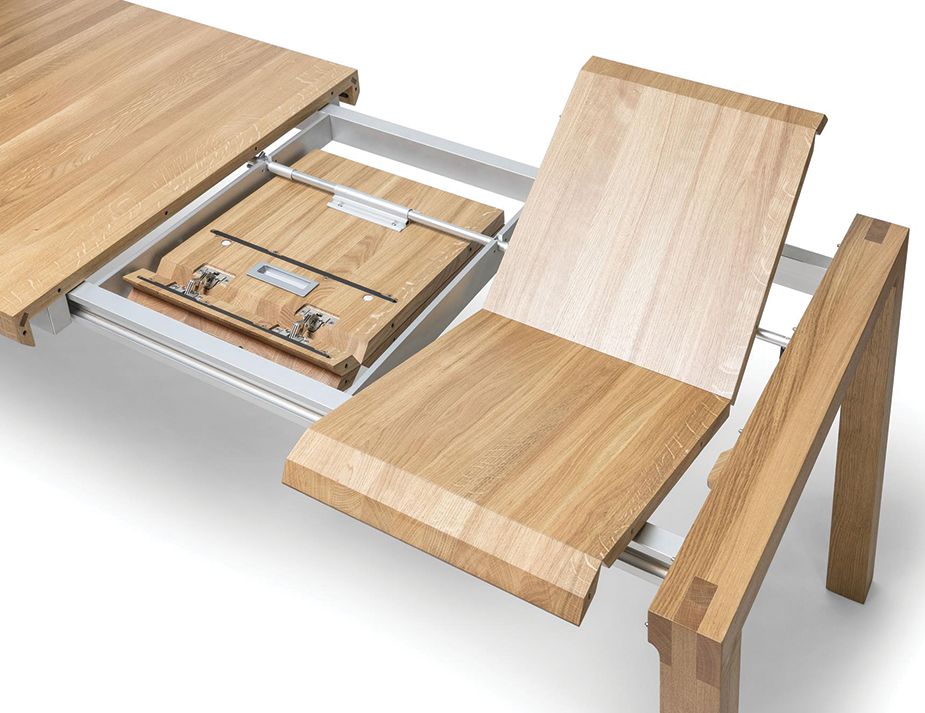 Close-up of a wooden extendable table mechanism showcasing its metal sliders and wooden sections.
