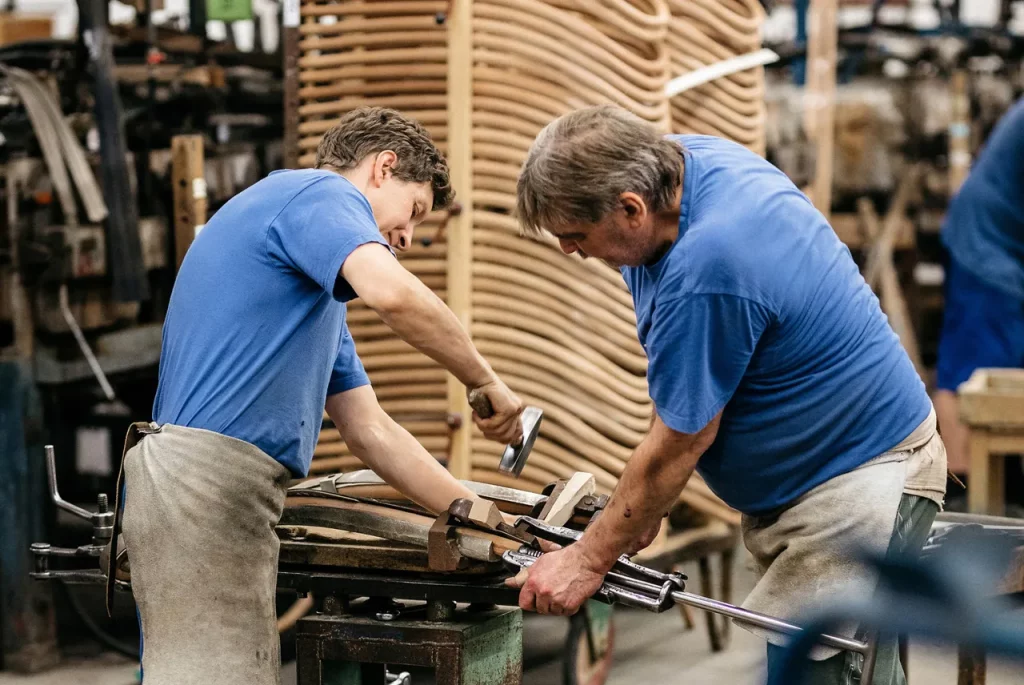 Two craftsmen in blue shirts working.