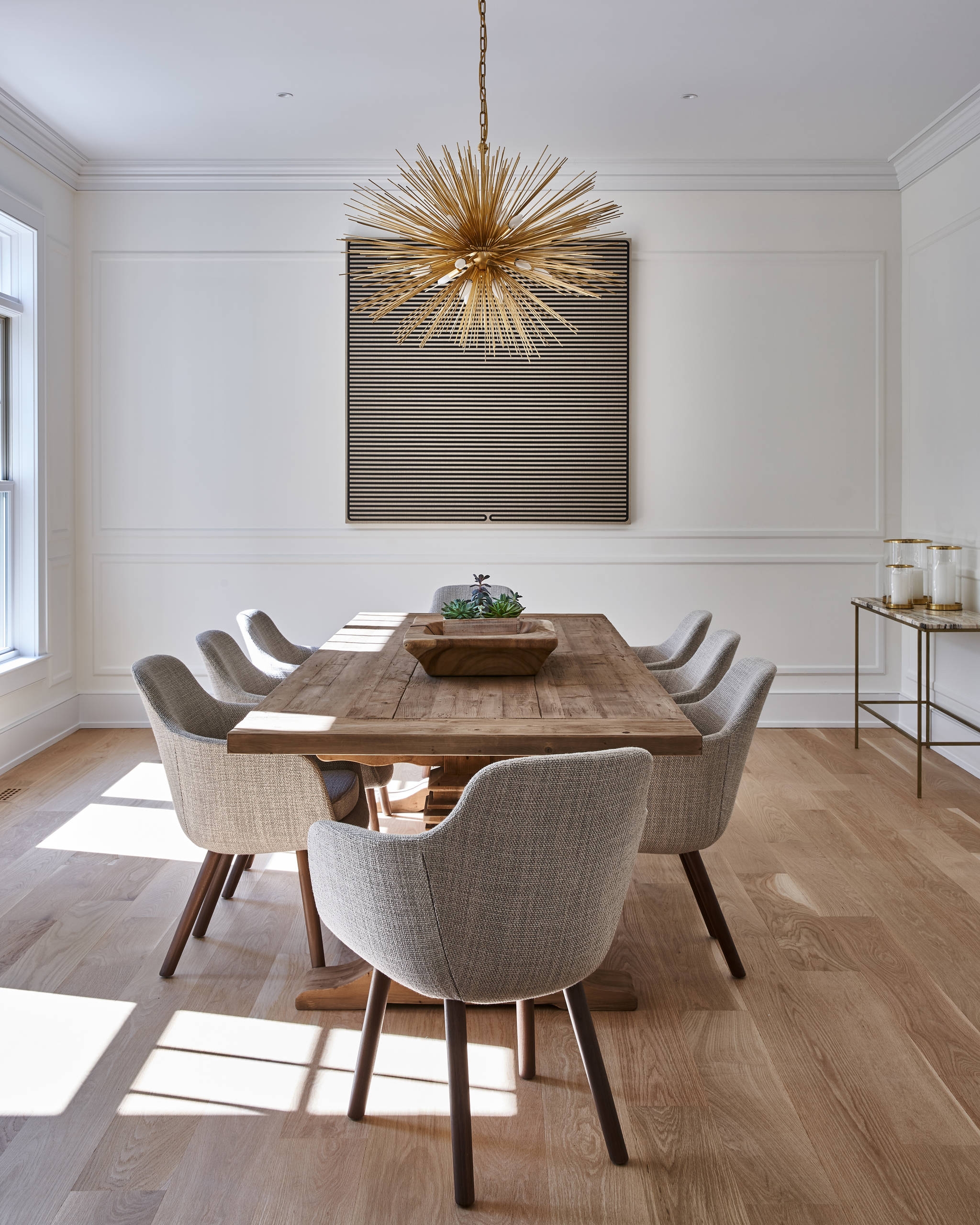 Dining room with wooden table & grey chairs.