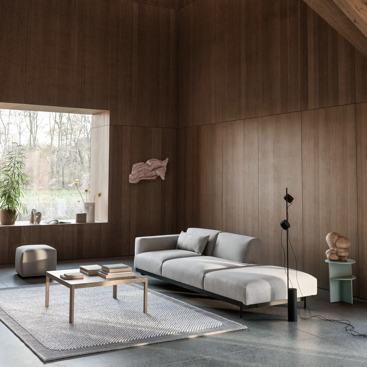 Modern Scandinavian sleek grey sofa, and a wooden coffee table.
