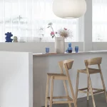 Bright kitchen bar with wooden stools and pendant light.