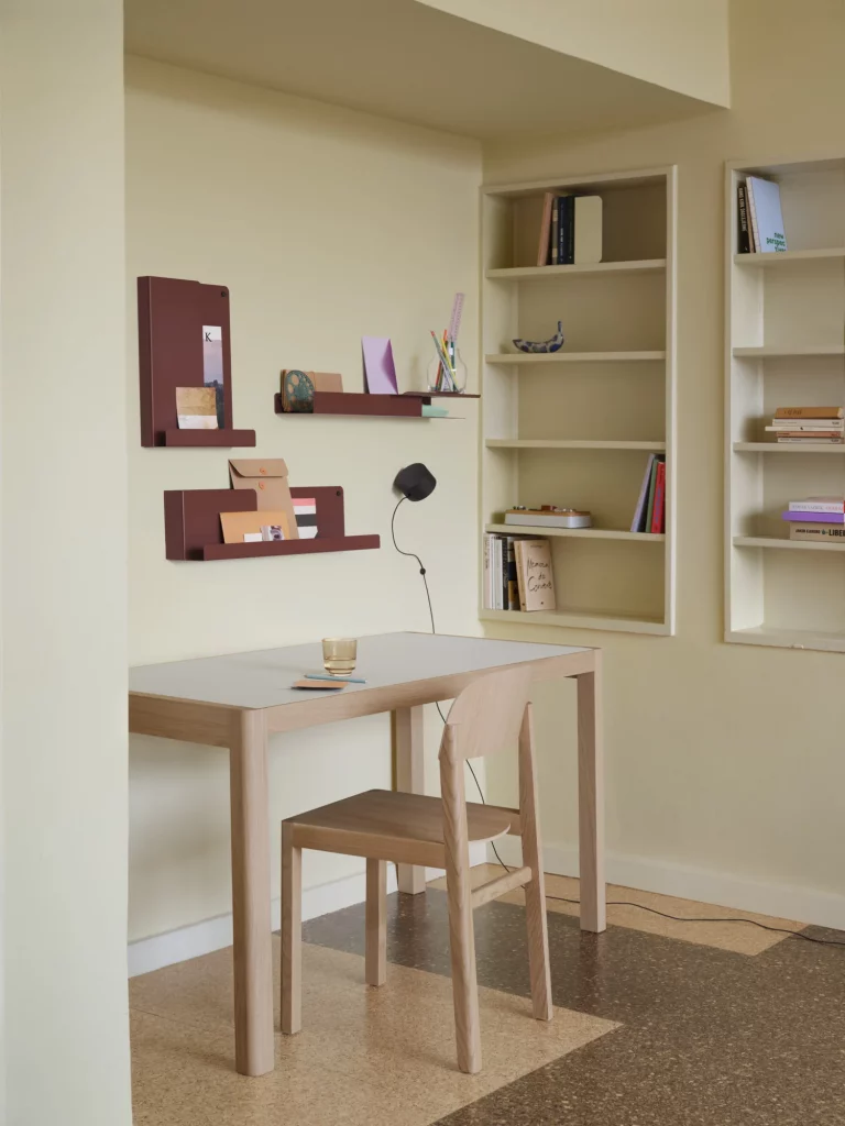 Simple study area with tan desk and floating shelves.