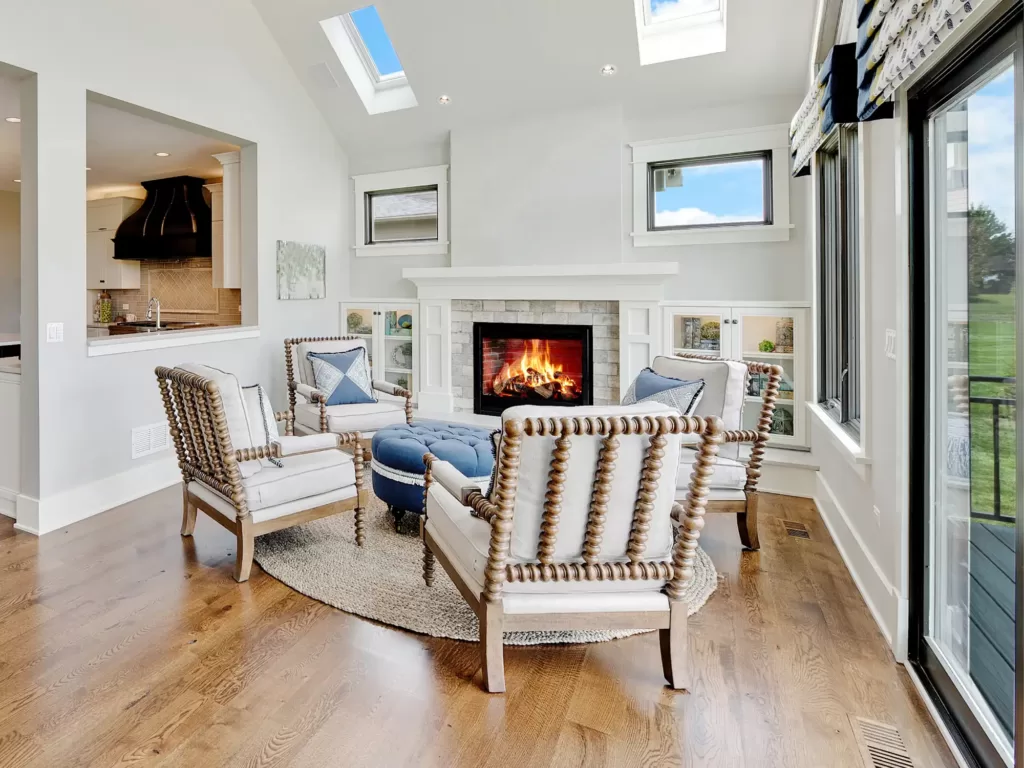 A cozy fireplace with 4 unique spindle-backed chairs.