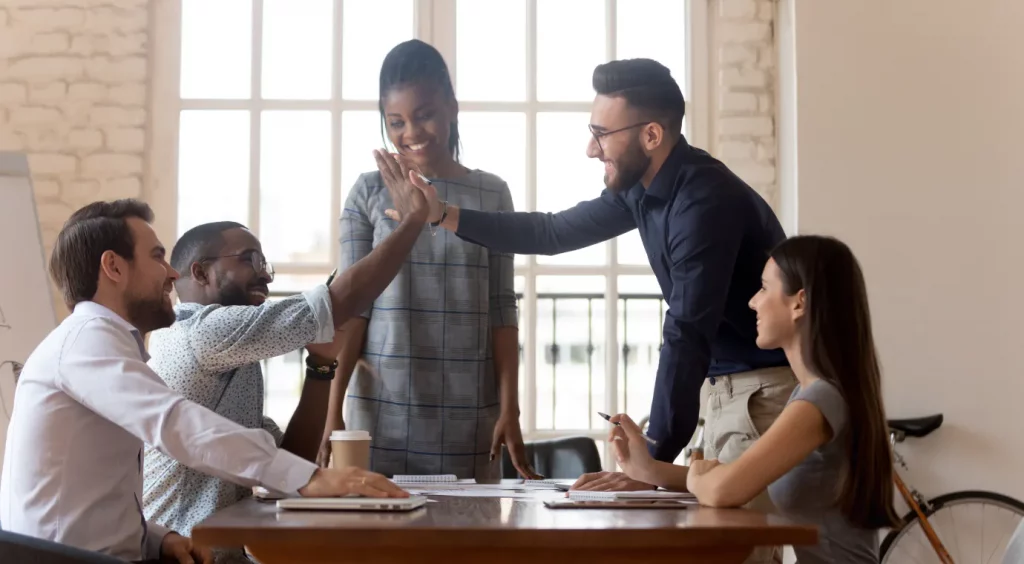 A diverse group of five professionals in a bright office setting.