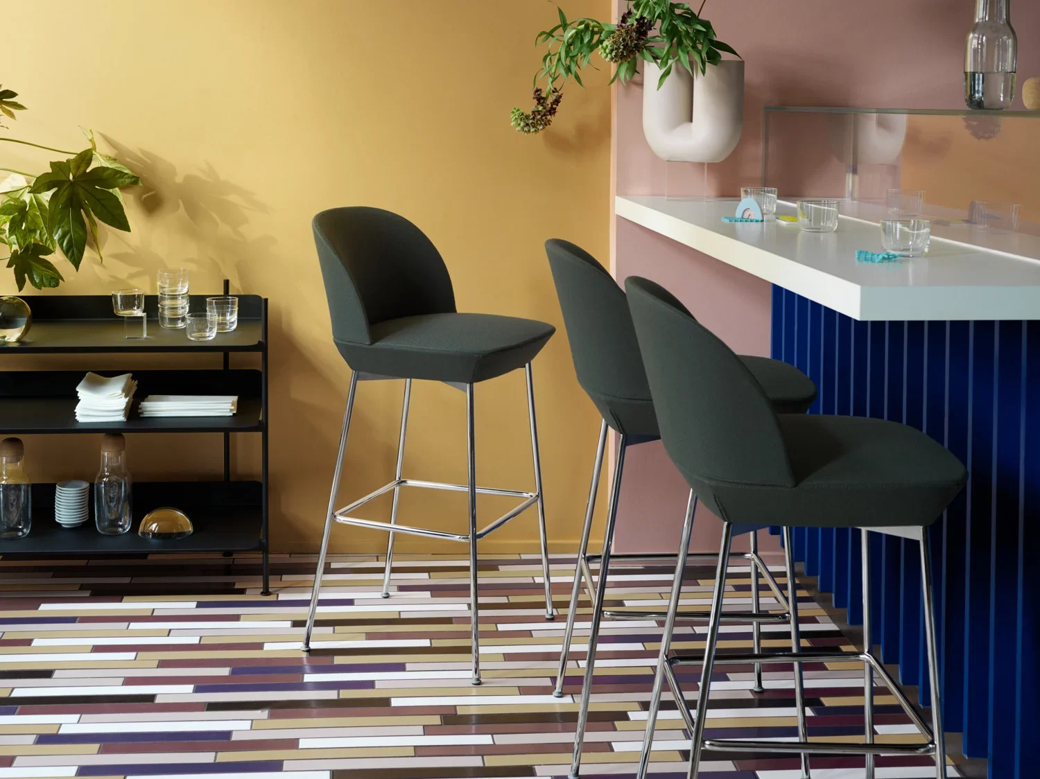 Kitchen bar area with teal cushioned bar stools.