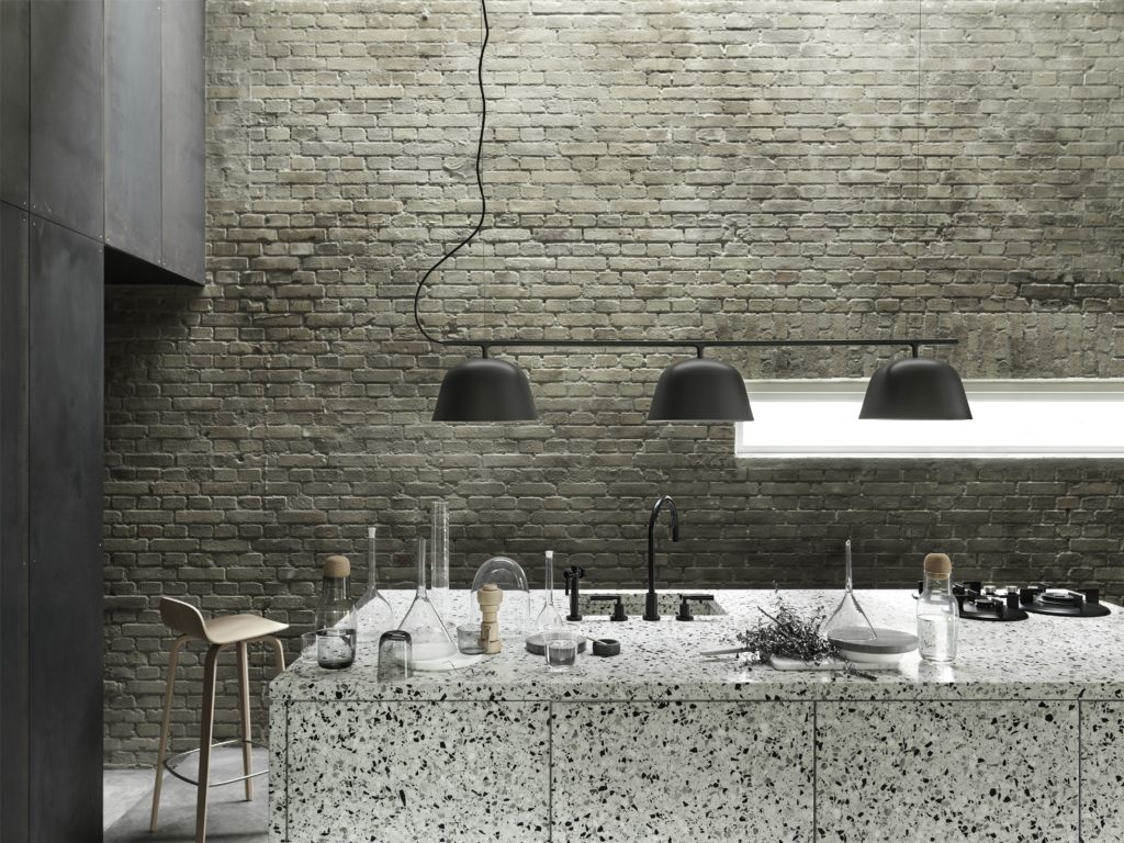 Industrial kitchen with black hanging lamps.