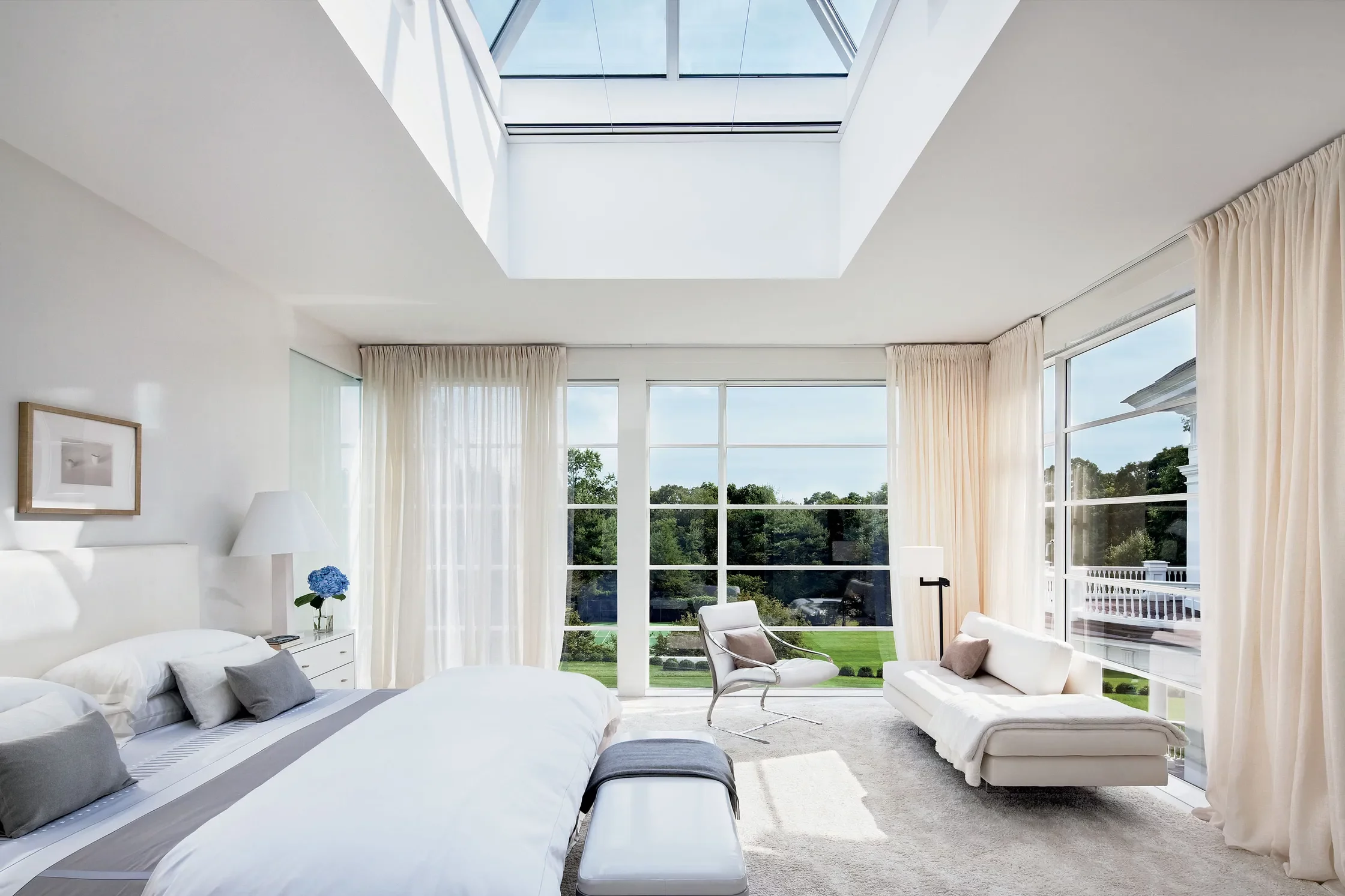 A bright bedroom featuring a large skylight