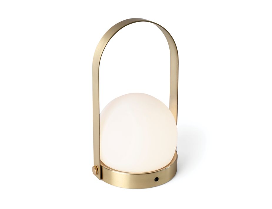A modern table lamp with a gold arch handle design.