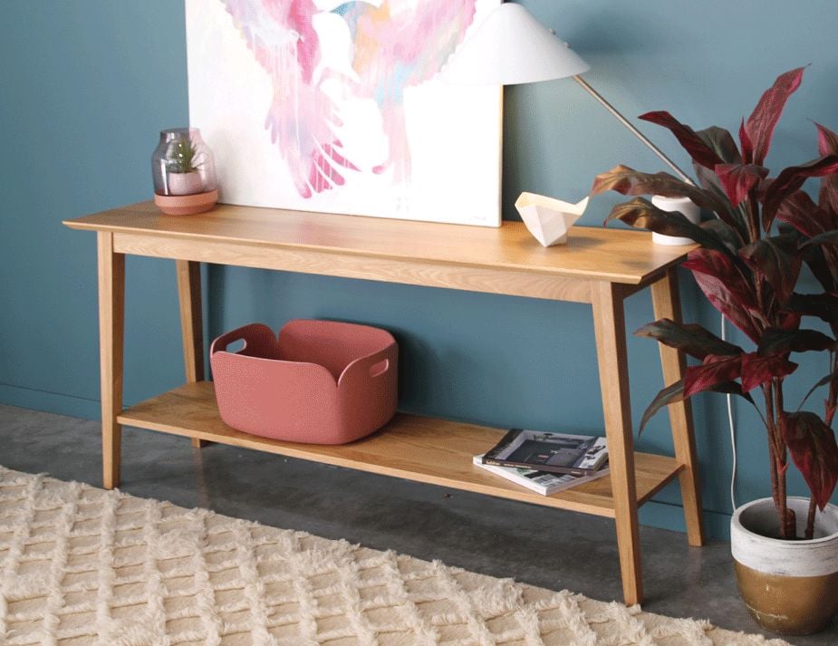 copenhagen console shelf A modern wooden console table against a teal wall.