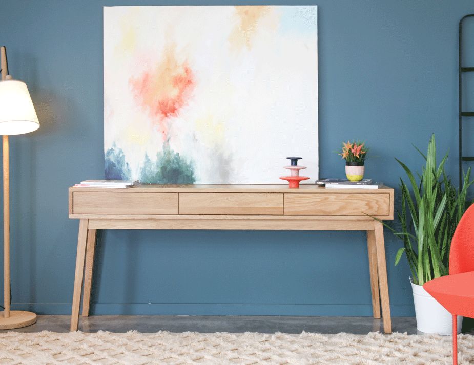 Wooden hallway table against a blue wall.