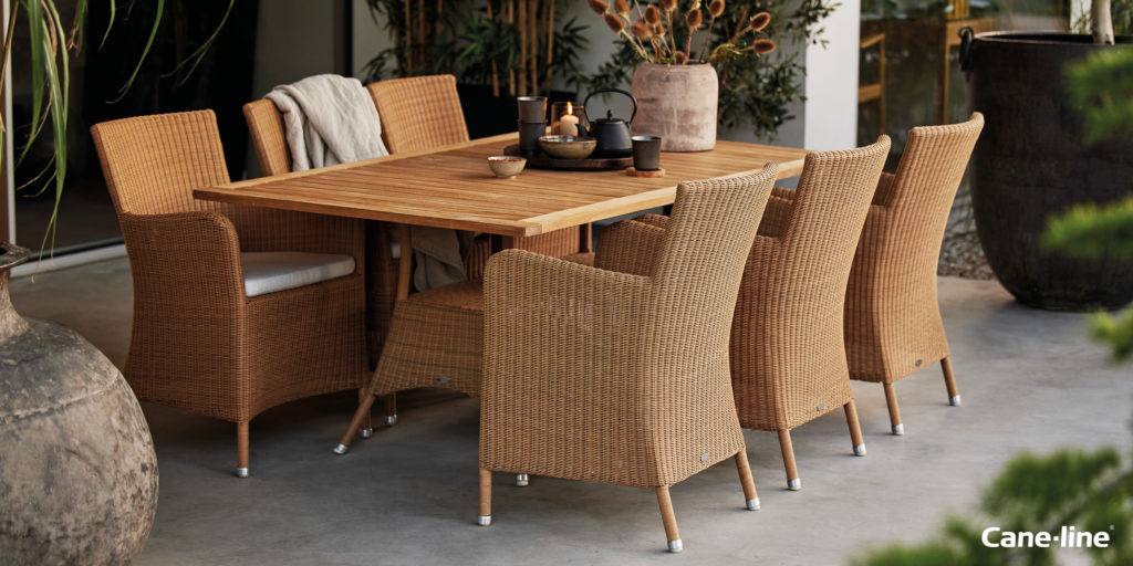 A rustic Cane-line dining set with wicker chairs.