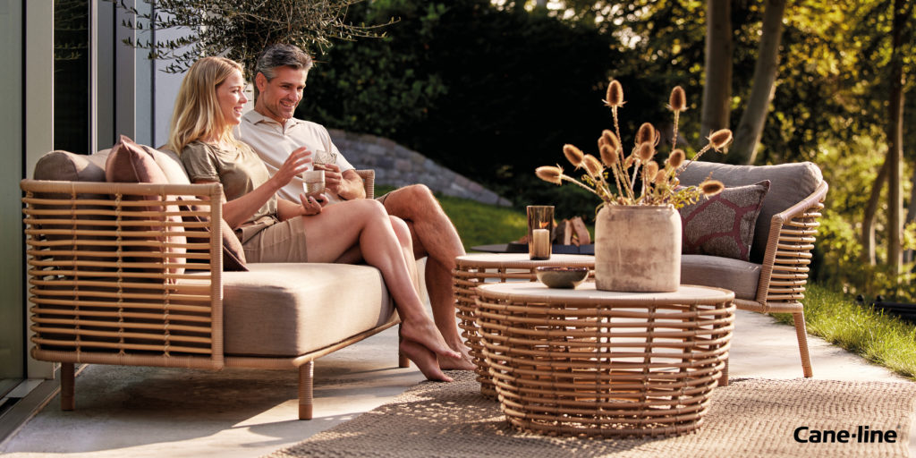 A couple relaxes on a unique Cane-line sofa.