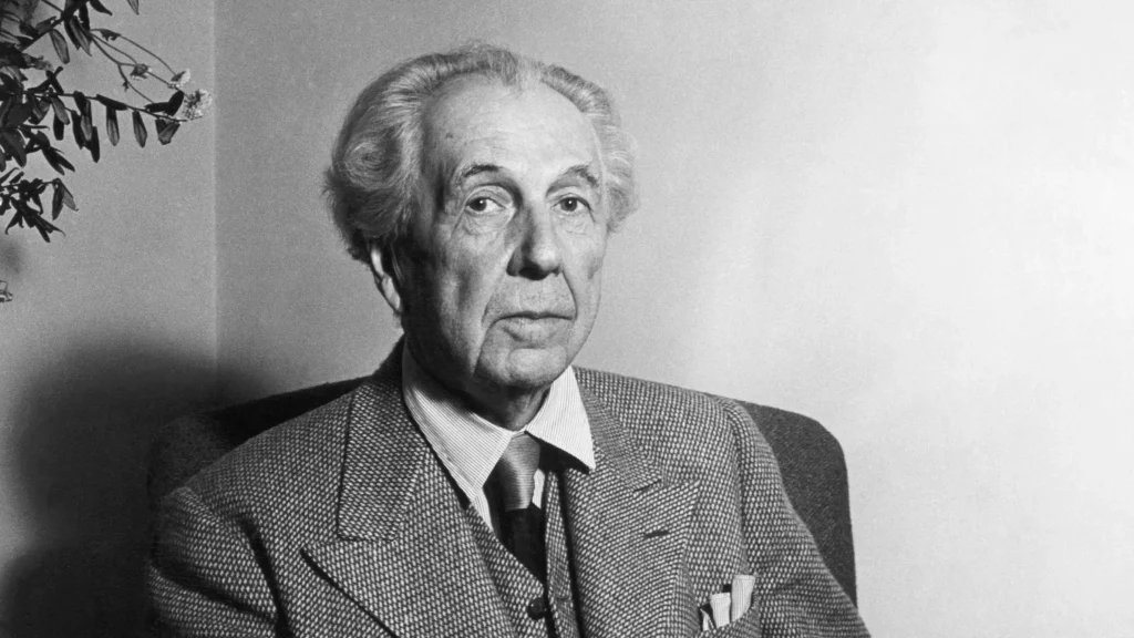 A black and white photograph of Frank Lloyd Wright.