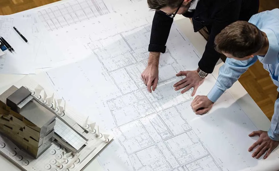 Group of professionals inspecting architectural blueprints.