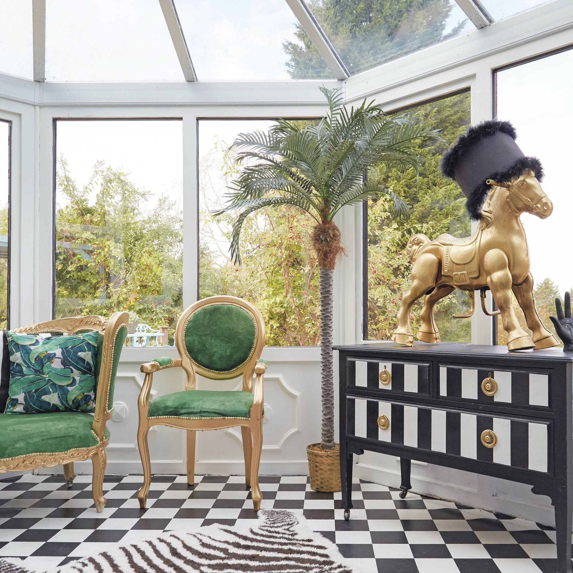 Whimsical sunroom with green chair and gold horse sculpture.