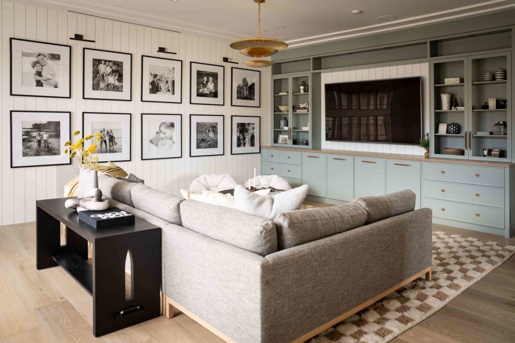 Chic living space with gallery wall and pastel cabinetry.