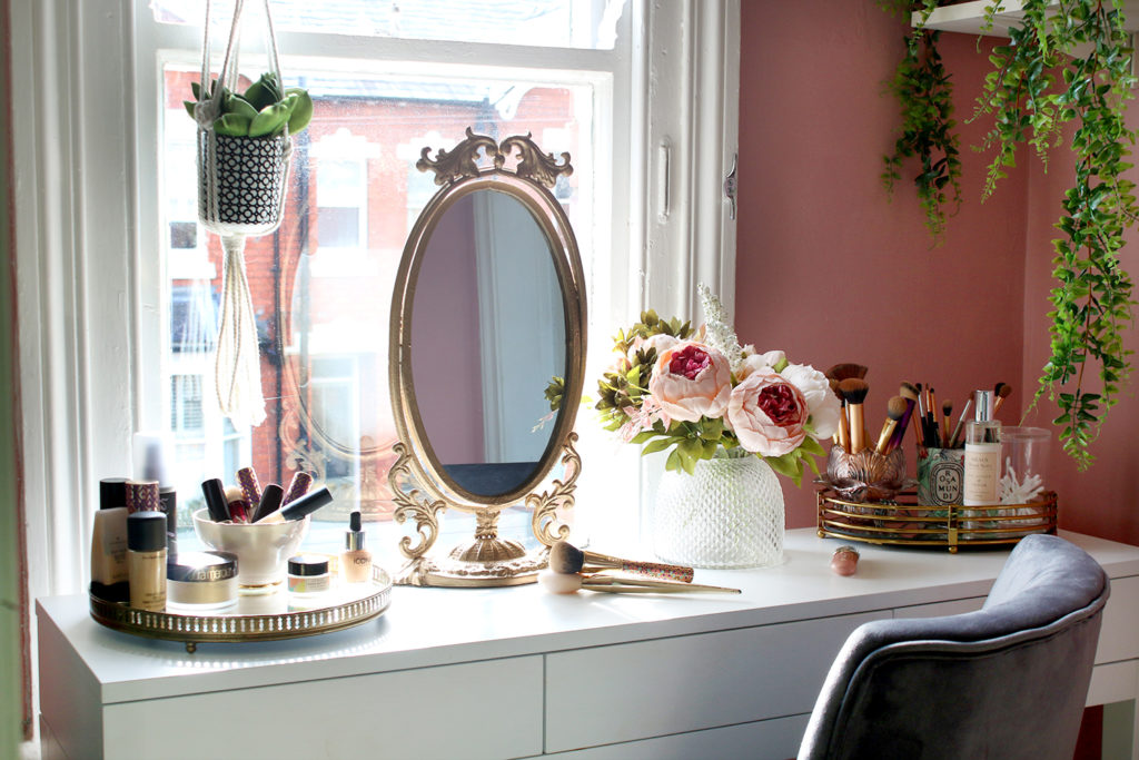 Vanity corner with a vintage gold-framed mirror.