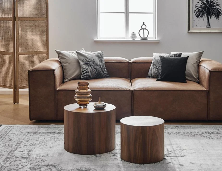 A modern living room with a brown round wooden coffee table.