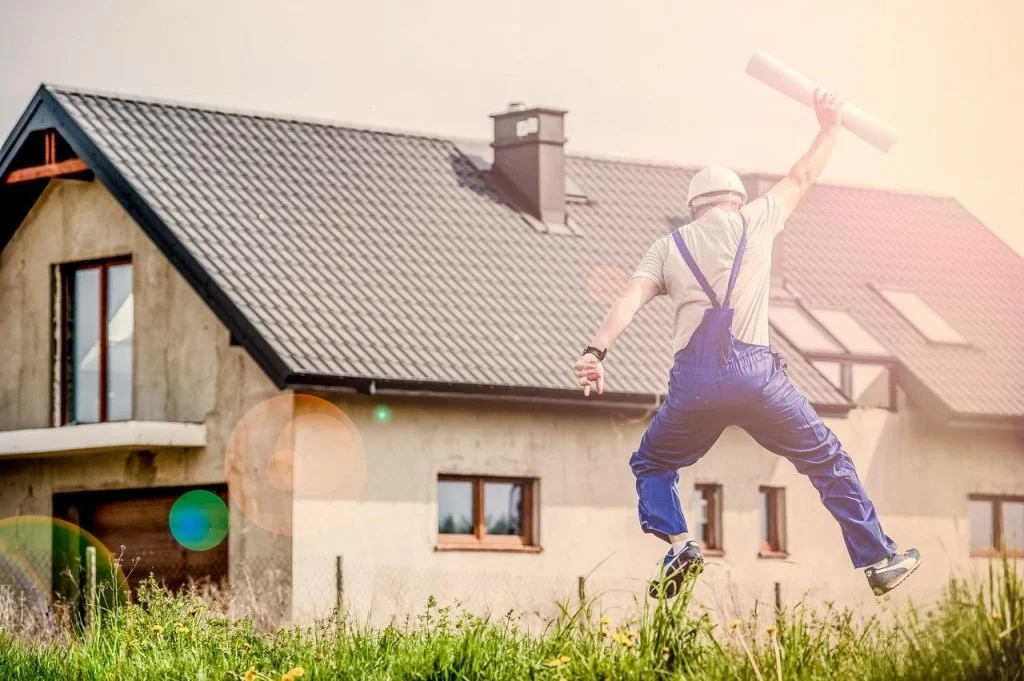 A construction worker leaps in the air.