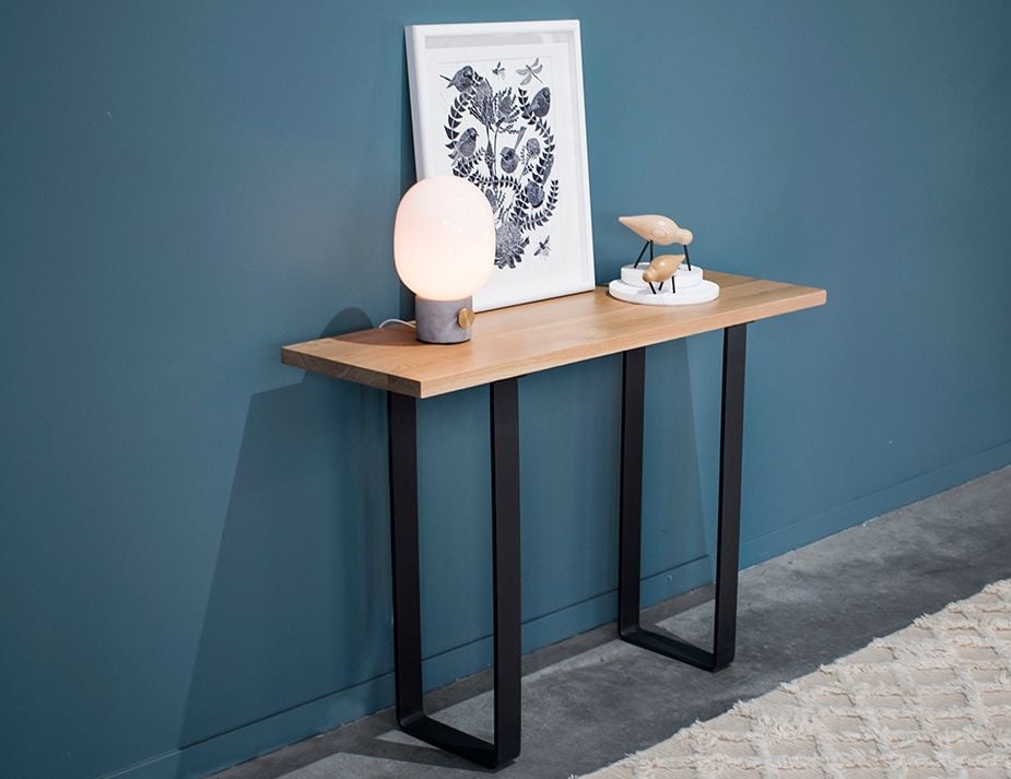 A minimalist console table against a blue wall.
