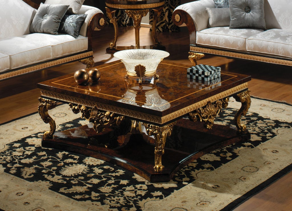 An ornate, antique-style coffee table with intricate gold details.