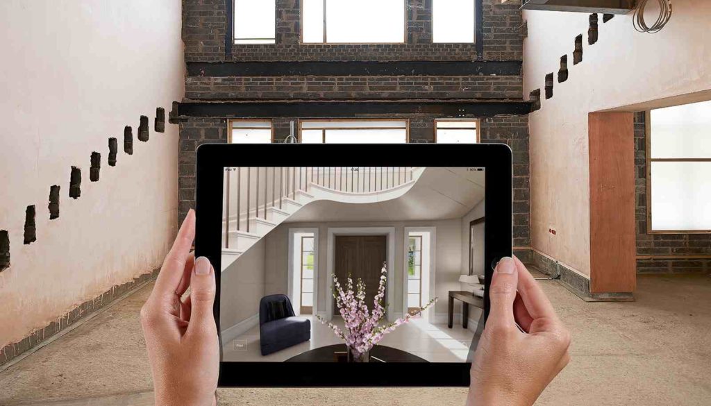 Hands holding a tablet that displays a modern room design.