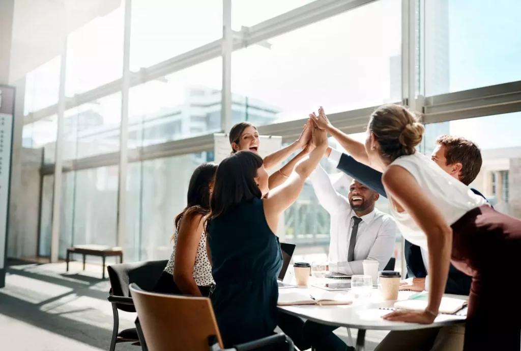 A group of home designers celebrating a success with a high-five.