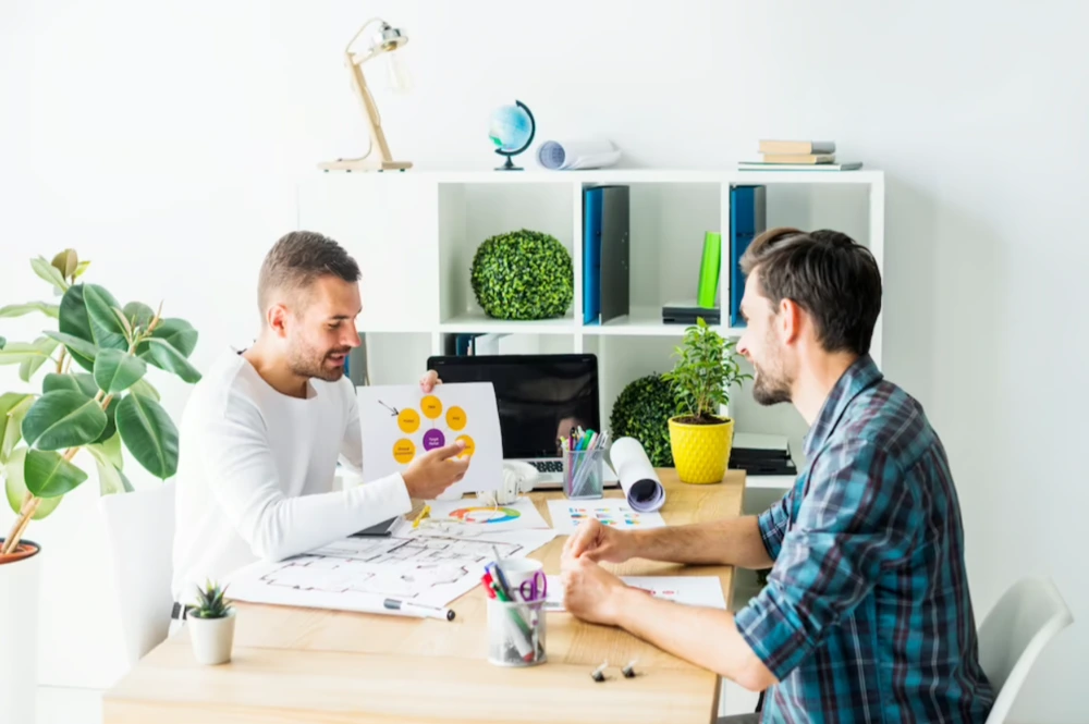 An interior designer and client reviewing a creative project on paper.