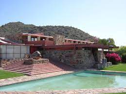 A sprawling red-brick house with expansive terraces.
