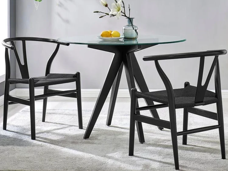 Elegant dining area with black chairs and glass table.