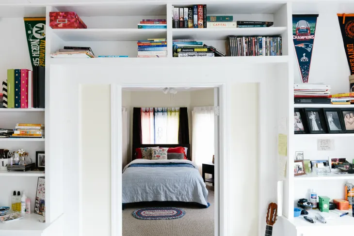 Unique reading nook with bookshelves above a doorway.