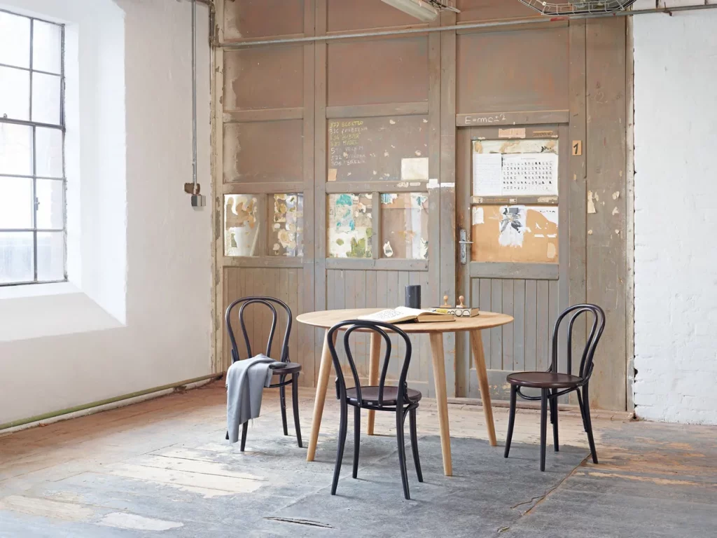 An industrial-themed dining space with bentwood chairs.