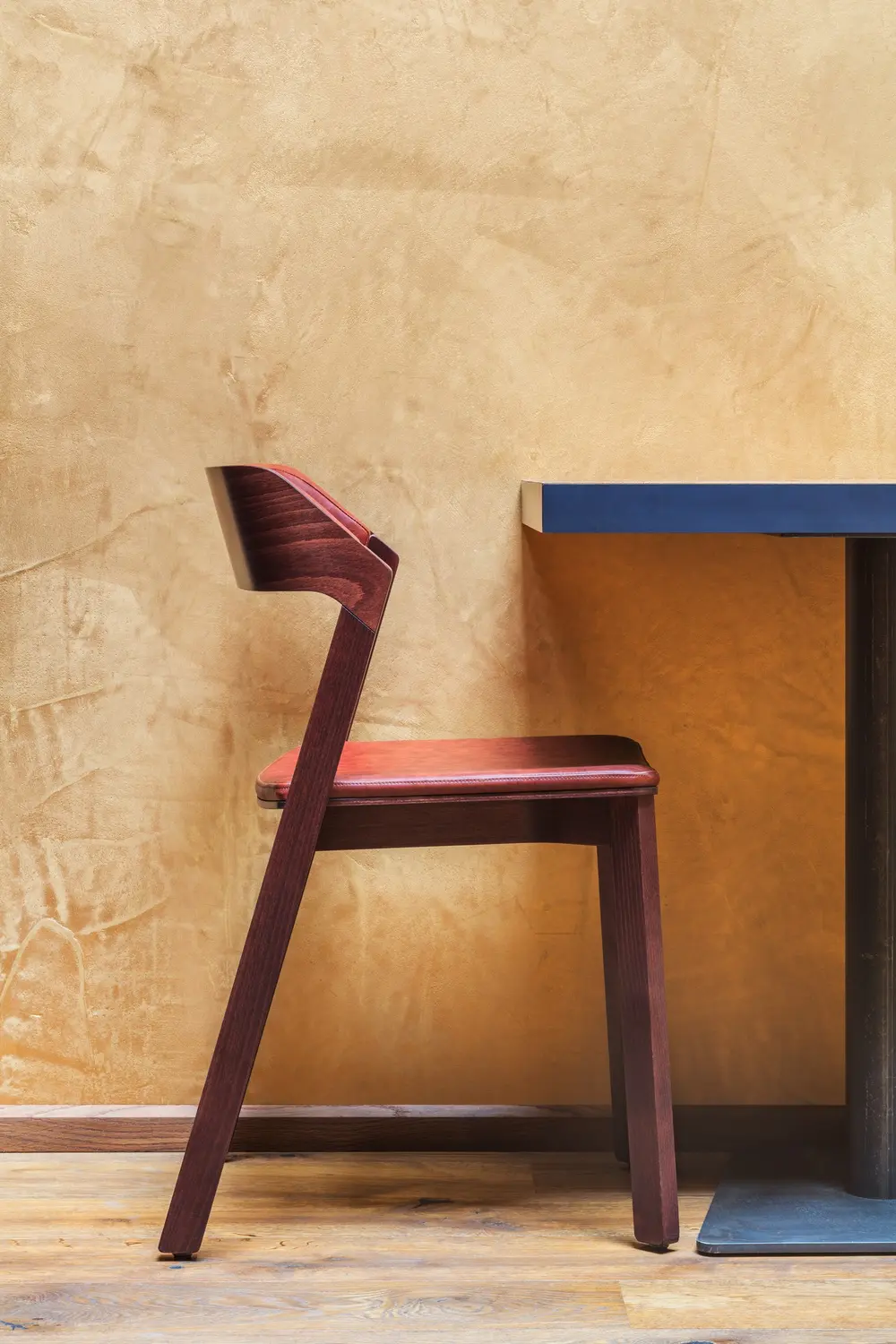 Dark wooden chair with a red leather seat.