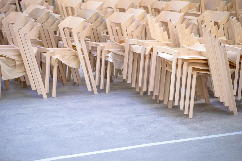 Merano dining chairs neatly stacked together in a warehouse.