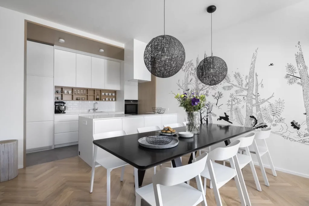 A contemporary kitchen with a table surrounded by white chairs.