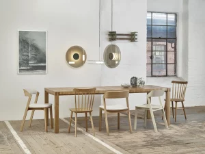 Wooden table surrounded by natural and white chairs.