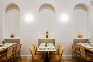 A dining area featuring rattan chairs with leather cushions.