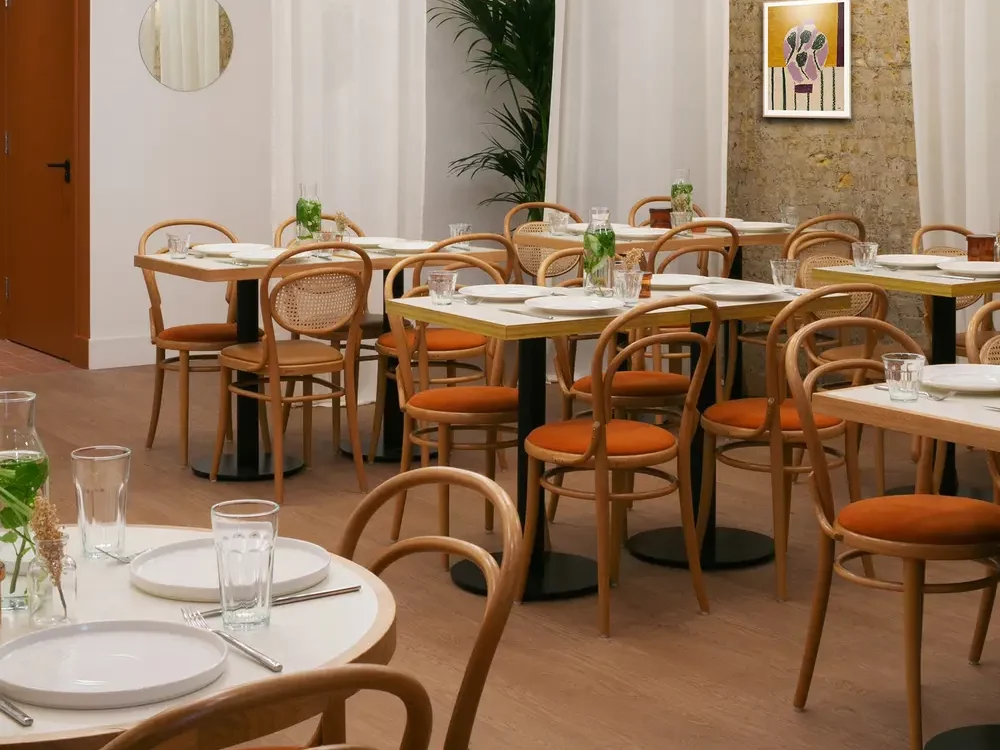 A cozy cafe corner featuring bentwood chairs and tables.