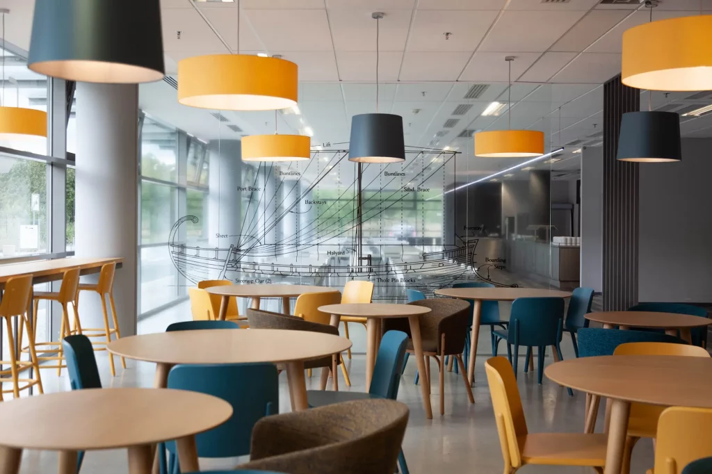 Spacious cafe with a mix of yellow and blue chairs.