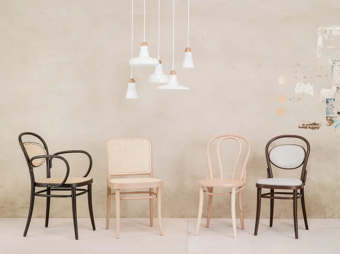 Four distinct bentwood chairs placed on a concrete floor.