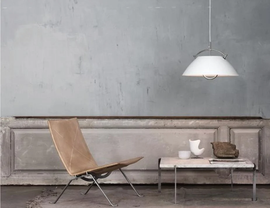 A minimalist room featuring a leather slingback chair.