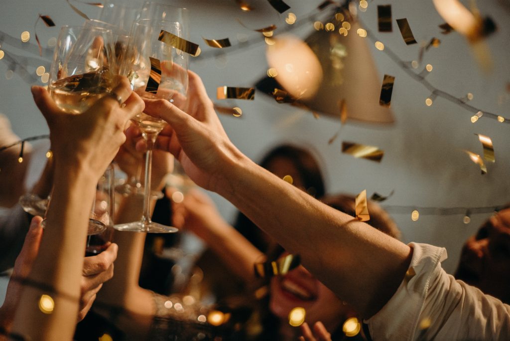 Hands raising wine glasses in a celebratory toast.