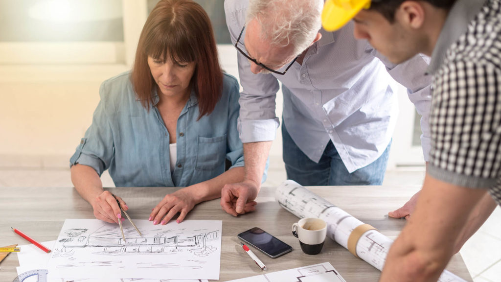 A woman marking changes on architectural plans.