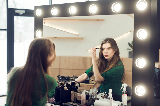 A young woman applying makeup.