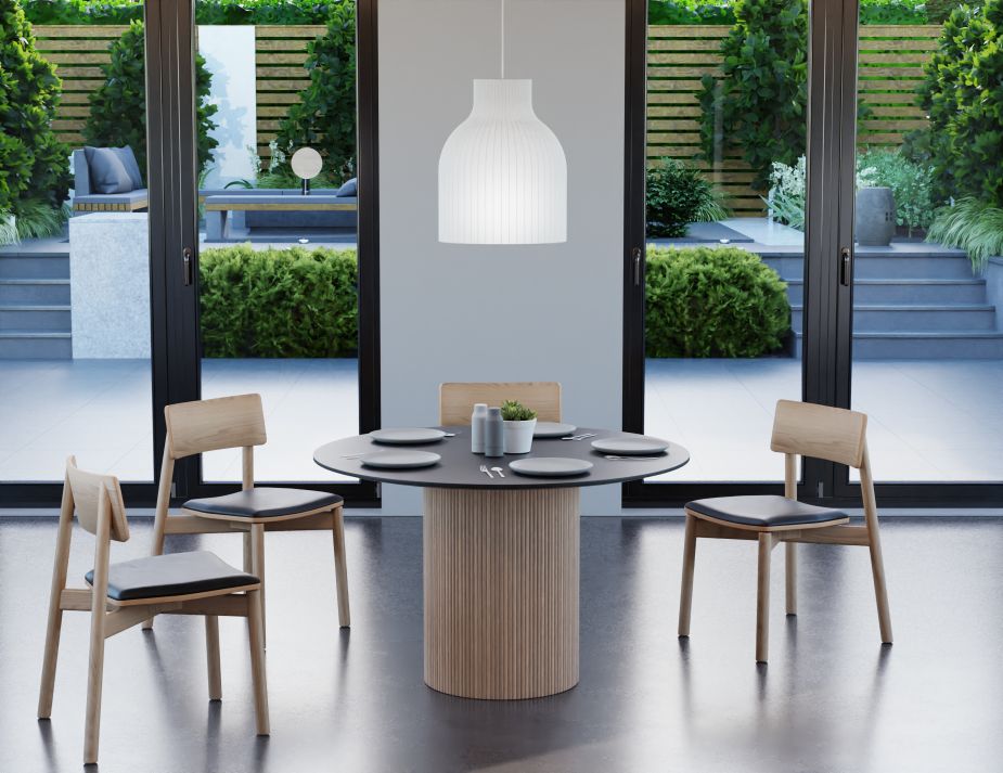 yes A contemporary dining area with wooden chairs and a table, set against a backdrop of large glass doors that open to a lush garden terrace. A white pendant light hangs above, illuminating the space.
