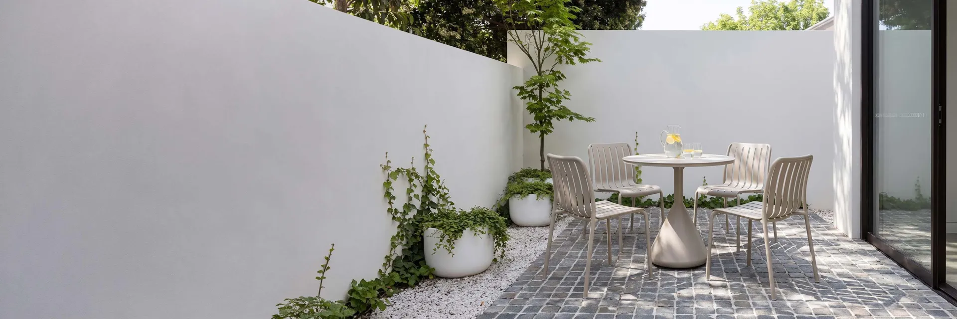beige dining table and chair in a small courtyard
